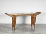 une table en bois avec un plateau en marbre posée sur un sol en béton