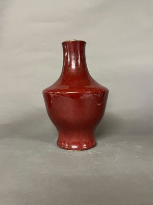 un vase rouge posé sur une table