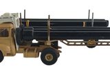 un camion miniature transportant un gros morceau de bois