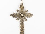 an antique silver cross with gold accents on a chain