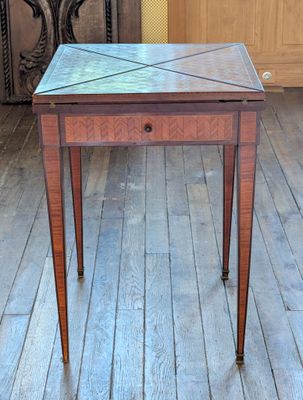 une petite table en bois avec un plateau en verre, posée sur un parquet