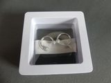 two wedding rings in a white box on a table