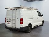 a white van parked in a room with a ladder on the roof