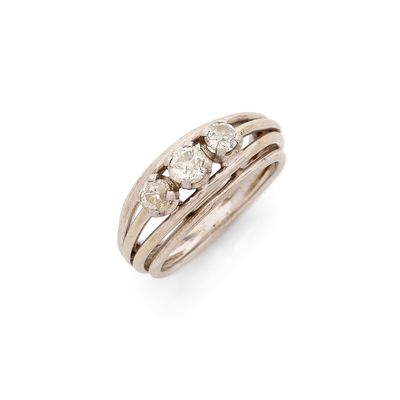 un gros plan d'une bague sertie de trois diamants sur fond blanc