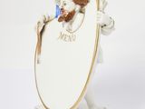 a figurine of a dog holding a mirror