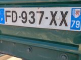a close up of a license plate on a green truck