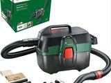 a black and green vacuum cleaner with tools and a box