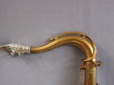 a gold saxophone that has a fish on it ' s neck