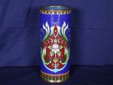 un vase bleu orné d'un motif rouge et vert