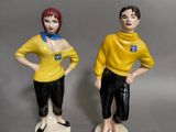 deux figurines d'un homme et d'une femme debout l'un à côté de l'autre