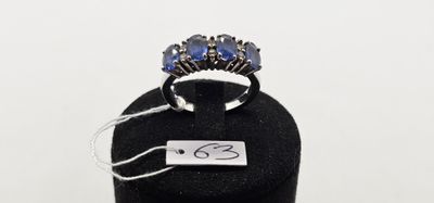 un gros plan d'une bague posée sur un présentoir noir