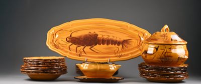 une assiette sur laquelle se trouve un insecte, à côté d'un bol et de tasses