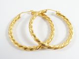 boucles d'oreilles en forme d'anneaux torsadés dorés sur fond blanc
