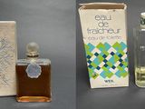 three bottles of perfume and a box of soap on a table