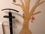 a wooden tree on the wall next to a chair