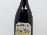 une vieille bouteille de vin posée sur une table blanche
