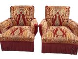 pair of upholstered chairs with red fringes on them