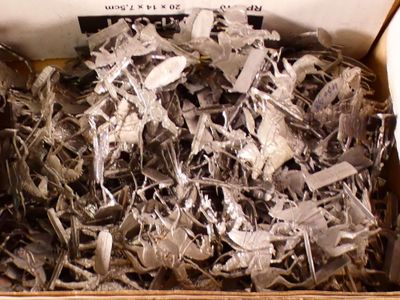 a cardboard box filled with lots of silver pieces