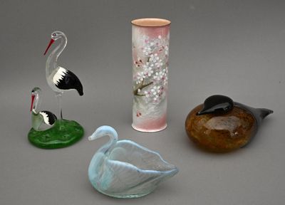 trois oiseaux en verre et un vase posés sur une table