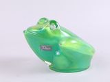 a green frog figurine sitting on a white surface