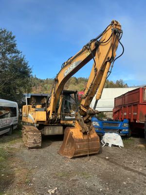 a yellow excavator that is sitting in the dirt