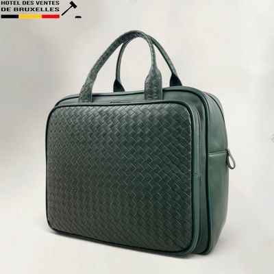 the green briefcase is sitting on a white surface
