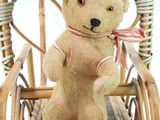 a teddy bear that is sitting in a chair