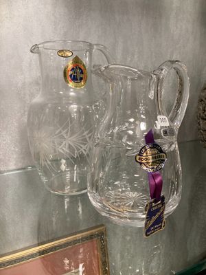 deux vases transparents posés sur une étagère en verre, à côté d'un tableau encadré