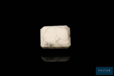 a close up of a white marble block on a black surface