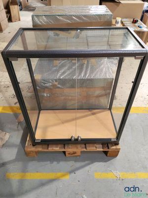 an empty glass display case sitting on a pallet in a warehouse