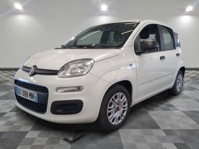 la petite voiture blanche est garée sur un carrelage à carreaux