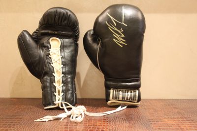 une paire de gants de boxe noirs posée sur une table en bois