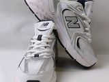 the new balance 991 is a white and black running shoe