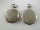 two silver pocket watches sitting on a white surface