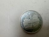 a silver coin with a picture of a castle on it
