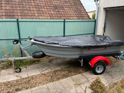 un bateau posé sur une remorque dans la cour