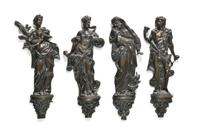 three bronze statues of women holding flowers and a bird on a pedestal