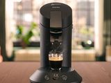 une cafetière posée sur une table, à côté d'une tasse de café