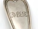 a silver spoon with a heart shaped handle on it