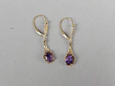 a pair of gold earrings with amethorate stones