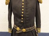 un uniforme noir à boutons dorés posé sur un présentoir pour mannequin