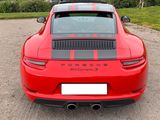 the rear end of a red sports car parked in a parking lot