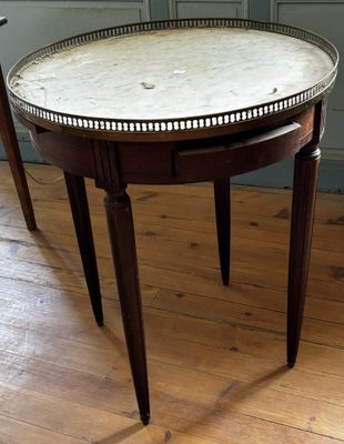 une table au plateau en marbre posée sur un parquet en bois massif