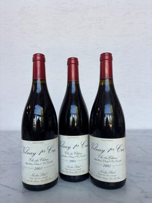 trois bouteilles de vin posées sur une table l'une à côté de l'autre