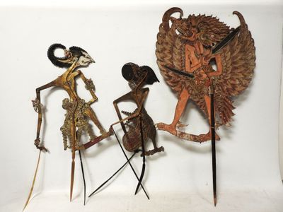 trois figurines en métal représentant une femme et un homme avec un oiseau sur la tête