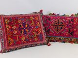 deux coussins aux motifs colorés et ornés de pompons