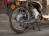 a moped that is parked in front of a brick wall