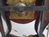 a clock that is sitting on a stand with a pendulum