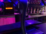 un bar avec un comptoir et des enseignes au néon accrochées au mur