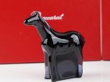 a black horse figurine sitting in front of a red box